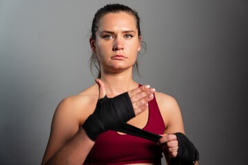 Portrait of a sporty female boxer on a grey background