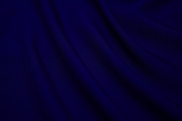 Texture of dark blue fabric closeup. Low key photo. Plexus threads. Clothing industry. Abstract background. Textile waves.