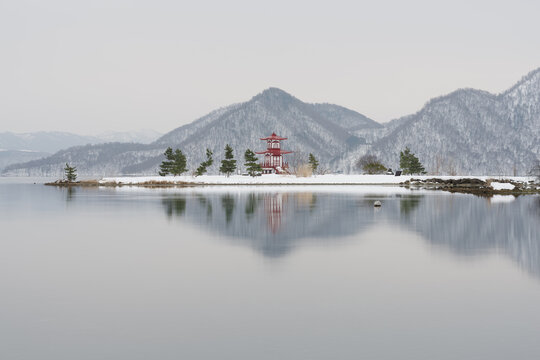 Ukimido temple at lake toya Hokkaido against winter mountains backdrop