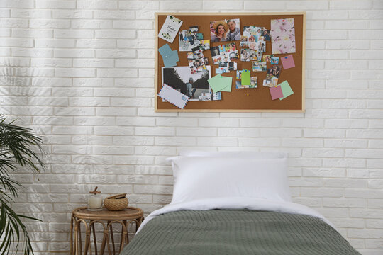 Stylish room interior with comfortable bed and vision board on wall