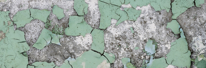 Peeling paint on the wall. Panorama of a concrete wall with old cracked flaking paint. Weathered...