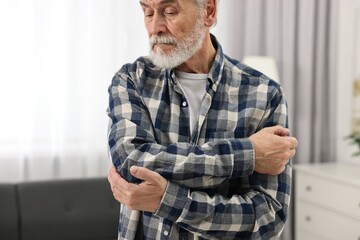 Arthritis symptoms. Man suffering from pain in elbow at home