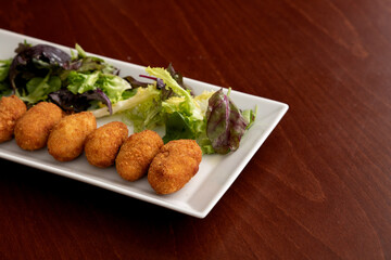 Spanish Tapas and Appetizers: Assorted Iberian Ham Croquettes, Roasted Chicken, Cheese, and Mushroom Plate with Lettuce