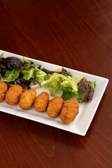 Spanish Tapas and Appetizers: Assorted Iberian Ham Croquettes, Roasted Chicken, Cheese, and Mushroom Plate with Lettuce