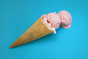 Ice cream in a waffle cone on a blue background with copy space