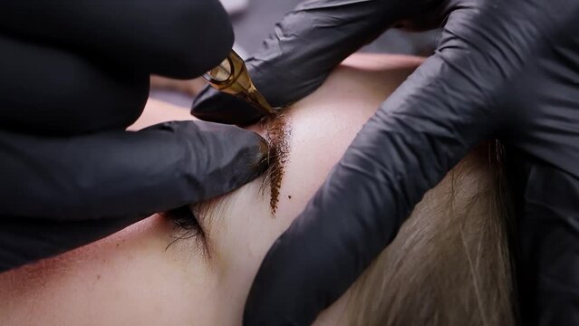 Close-up of a cartridge from a tattoo machine that introduces pigment into the skin of the eyebrows. Permanent makeup procedure, performing PMU of eyebrows