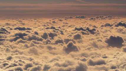 Captured from a plane, the photo showcases clouds resembling cotton, their billowy formations...