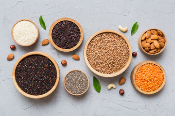 Various superfoods in smal bowl on colored background. Superfood as rice, chia, quinoa, lentils, nuts, sesame seeds, almonds. top view copy space