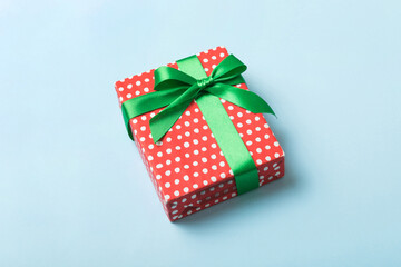 Wrapped christmas or other holiday handmade present in paper with colored ribbon. Present box, decoration of gift on table, top view with copy space