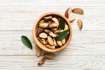 Fresh healthy Brazil nuts in bowl on colored table background. Top view Healthy eating bertholletia concept. Super foods