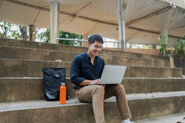 business man sitting on bench and working remotely on project with laptop