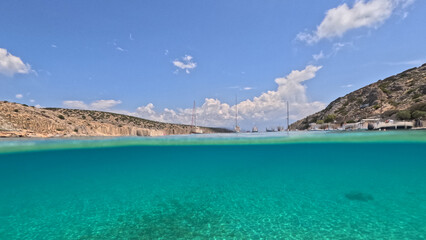 Underwater split photo of paradise crystal clear sea beach of Agios Georgios in main port of...