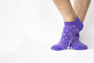 unshaven women's legs, with long black hair, wearing purple ankle socks to reclaim equality between men and women