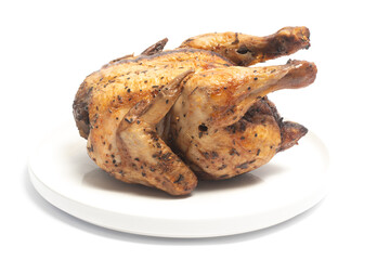 A whole delicious roasted chicken seasoned with herbs in a white plate isolated on white background clipping path