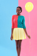 Black woman, fashion and portrait, balloon and smile or happiness with color block background. Stylish, trendy and vibrant for female model person, fun and unique retro clothing for hipster in studio