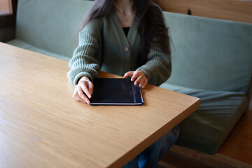 Woman Sitting at a Wooden Table Holding a Restaurant Menu
