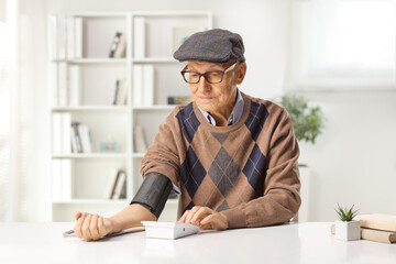 Elderly man checking blood pressure with a digital device