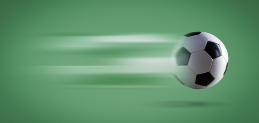 Fast soccer ball on green background