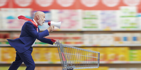 Fast businessman pushing a shopping cart and shouting into a megaphone