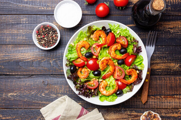 Salad with shrimps, tomatoes, olives and nuts. Healthy eating.