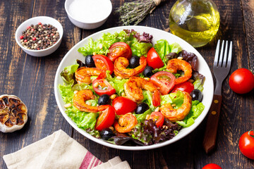Salad with shrimps, tomatoes, olives and nuts. Healthy eating.