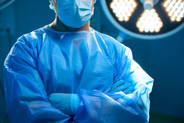 Unrecognizable man surgeon standing with arms crossed in operation theater