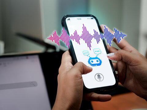 Conversation and voice searching automation, voice recognition technology concept. Artificial intelligence conversational assistant technology with chat bot symbol on smart phone screen in woman hand.
