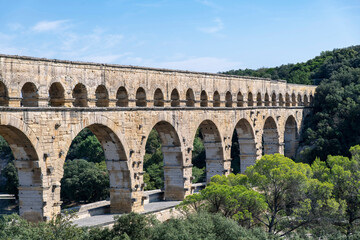 High angle partial view of the aqueduct bridge Pont du Gard over the Gardon river near Vers-Pont-du-Gard, France with well-preserved arched tiers, built by 1st-century Romans