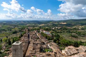 Fototapeta na wymiar High angle panoramic view over San Gimignano, Italy with view on the tower Torre dei Cugnanesi and typical Tuscan landscape in the background