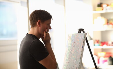 Portrait of talented young man creating masterpiece. Artist thinking on idea for painting and...