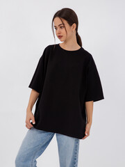 mockup of a black loose-fitting t-shirt on a young beautiful girl