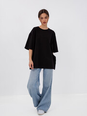 mockup of a black loose-fitting t-shirt on a young beautiful girl
