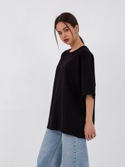 mockup of a black loose-fitting t-shirt on a young beautiful girl