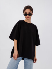 mockup of a black loose-fitting t-shirt on a young beautiful girl