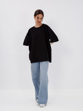 mockup of a black loose-fitting t-shirt on a young beautiful girl