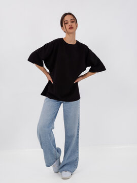 mockup of a black loose-fitting t-shirt on a young beautiful girl