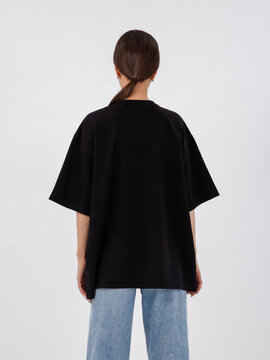 mockup of a black loose-fitting t-shirt on a young beautiful girl