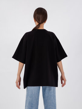 mockup of a black loose-fitting t-shirt on a young beautiful girl