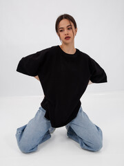 mockup of a black loose-fitting t-shirt on a young beautiful girl