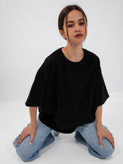 mockup of a black loose-fitting t-shirt on a young beautiful girl