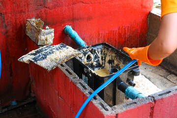 Grease traps from dirty debris being cleaned with a scoop are discarded. How to treat water with a...