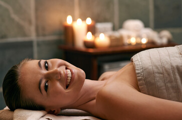 Happy, woman and portrait in spa with candles at night for luxury treatment in hotel on vacation. Girl, relax and smile for cosmetics, skincare and holiday at resort to care for beauty and wellness