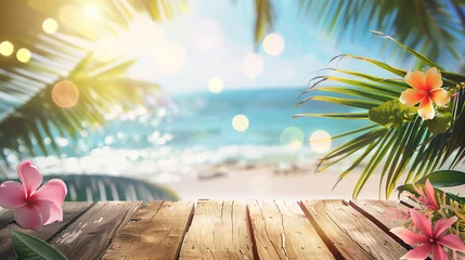 Foto auf Glas An empty wooden table adorned with plumeria flowers and palm leaves sits against an ocean backdrop, illuminated by bokeh sunlight. Background for displaying summer and tropical beach products. © Bnz