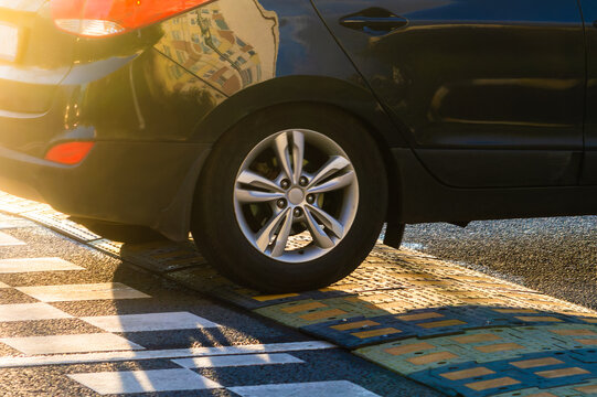 A passenger car drives over an speed bump on the road