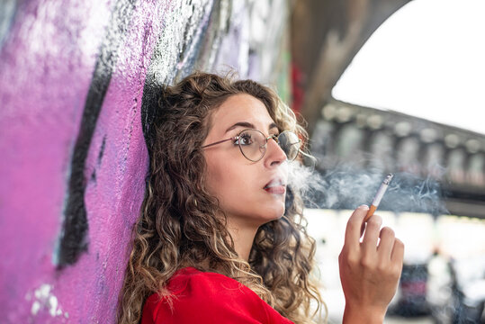 nachdenkliche junge Frau raucht eine Zigarette