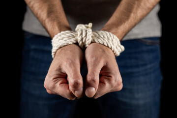Man's hands tied with a rope Close up