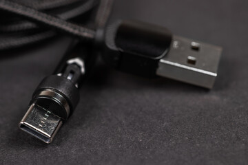 Usb cable close up on a black background used to transfer information, hardware connection