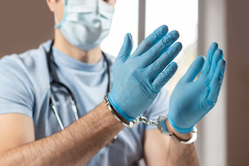 A medical officer, doctor, or quack in a blue medical uniform in handcuffs.