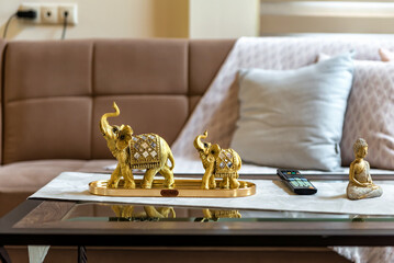 Elegant Living Room Decor: Golden Elephant Figures Adorn Sofa Side Table. Perfect for illustrating...