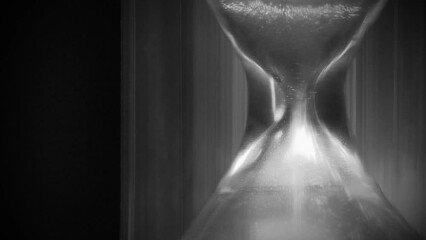 Hourglass. Sand is falling down. Past and present. Time is like sand in endless desert, but remember, your handful is in hourglass. 4K macro shot video in retro style with cinema effects, old filming